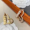 23ss orecchini da donna firmati orecchini a bottone Peach heart hollow pearl logo con trapano a bottone Il Medioevo squisito temperamento orecchino gioielli da donna a1