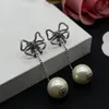 Vrouwen modeontwerper stud gouden zilveren bowknot oorbellen witte parel eenvoudige stijl messing engagement lange oorrel