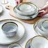Tallrikar keramiska marmorgrå servisuppsättningar och skålar middag efterrätt aptitretare platta rätter för hemrestaurang el present