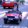 子供用電気自動車屋外のおもちゃで四輪車の大人ベビーカーに乗っている車に乗って子供のための車に乗る