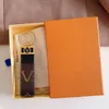 Llavero de cuero de alta calidad Clásico Exquisito Diseñador de lujo Llavero de coche Letra de aleación de zinc Cordón unisex Oro Negro Metal Caja de regalo de joyería pequeña 14 colores