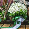 装飾的な花ハイエンドジプソフィラを保持して花を抱く花嫁花嫁の結婚式の撮影小道