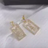 Luxury chandelier earrings with rhinestones in gold. Plate Alphabet Pendant Designer Earrings for Women. Valentine's day gift designer jewelry for women.
