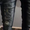 Jeans de rock revival da moda de rua com buracos rasgados, remendos bordados lavados em azul e preto, calças justas, homens religiosos da tendência masculina