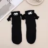 Chaussettes magnétiques amusantes avec mains pour hommes et femmes, vente en gros, mode noir et blanc, yeux de dessin animé mignons, chaussettes en coton à mi-tube, cadeau