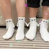 Chaussettes magnétiques amusantes avec mains pour hommes et femmes, vente en gros, mode noir et blanc, yeux de dessin animé mignons, chaussettes en coton à mi-tube, cadeau