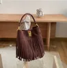 Bolsa balde retrô versátil com borla fosca para mulheres 2023 outono/inverno Nova bolsa de alta capacidade de um ombro crossbody com fivela e cor marrom profundo