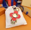 Keychain de haute qualité Classic Luxury Designer Sun-Flower Key Chain Men Men de voiture Course Femmes Boucle Keychains Sacs Pendante avec boîte et sac à poussière T105