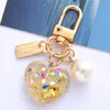 Bling Acrylic Heart KeyChain med färgglad paljett Söt pärlmetallmärke Keyring för kvinnor flickor öronväska dekoration