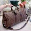 Bolsas de viagem de designer popular PU Bolsas de viagem de moda masculina e feminina Tote de grande capacidade Bolsa de viagem de couro de lona revestida clássica impressa Bolsa de embarque Bolsa tote