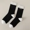 Damensocken der trendigen Marke Schwarz-Weiß-Prägebuchstaben Minimalistische mittellange Baumwollsocken