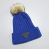 Ontwerpers beanie hoeden warme pluche herfst winter vrouwen massieve kleur pom pom caps mode gebreide pet wollen hoed