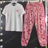 Womens Two Piece Pants Trendy Gold Flower Print Kort ärm T-shirt med bruna logotypbyxor 2-stycken Set Luxury Designer Tracksuits324T