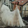 Graziosi abiti da sposa senza schienale Abiti da sposa bohémien arruffati Scollo a V Una linea Sweep Train Tulle vestidos de novia