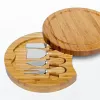 Бамбуковые кухонные инструменты сырная доска и ножи, расположенные вокруг колбаковых досок, поворотные мясные блюда.