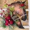 Decoratieve bloemen kerstdecoraties buitentuin krans paardenhoofd dressuur houten deur hangende lente