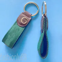Metall Round Key Chains Plated Gold Bag Charms Wallet Mini Dekorera Simply Man Portachiavi Klassisk designer Keycahins Red Green Mixed Webbing PJ055 B23