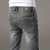 Jeans masculin Spring and Summent Middle Taist Jeans Small Straight Tube Trend Elastic Pantalon décontracté polyvalent