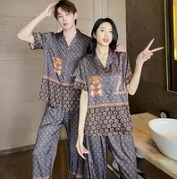 Pijama de seda 23SS Define letras têxteis caseiras imprimem homens casuais homens casal de manga curta Cardigan de calça de calça de dormir pequena roupa de vento doce
