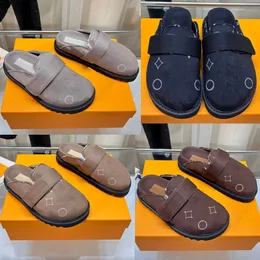 A parte superior dos tamancos de designer Cozy Flat Comfort Clog 1AC9N9 apresenta uma alça ajustável em couro de bezerro camurça coordenado que é embelezada com um logotipo em tom dourado 35 42