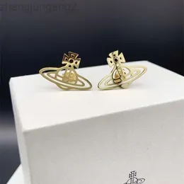 Gli orecchini Saturno piatti cavi e lucidi in oro e argento della designer Viviane Westwoods Viven Empress Dowager Xis sono una nicchia femminile con stili alla moda e minimalisti