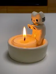 Ljus kattunge ljushållare kattunge värmer sina tassar