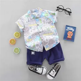 Kleidung Sets 2pcs Baby und Kleinkind Sommer Mode Ganzkörper Cartoon Dinosaurier Kokosbaummuster zufällig gedrucktes Taschenhemd Shorts Set J240518