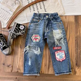 2024 Spring Kids Hole Jeans Boys Cartoon Letra Apliques de jeans de jeans da moda Crianças Casual Cowboy Troushers S1301