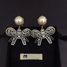 2024 Designer Mui Mui Jewelry Family Miao Families New Gold Bowknot Pearl Earrings French Light Luxury Overdrived Temperament Fairy Silver Needle