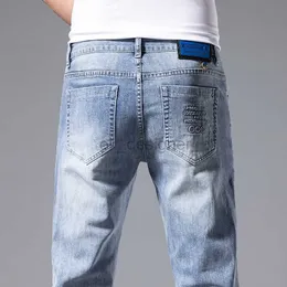 Jeans de jeans masculino Jeans Men's Spring and Summer Novo elástico ligeiramente solto de calça de jeans da moda pequena da marca de pé versátil