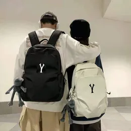 同じカップルのバックパックを持つ男性と女性は、パンを運ぶ大学生と一緒にシンプルなレジャーの男子袋をマザーバックパック