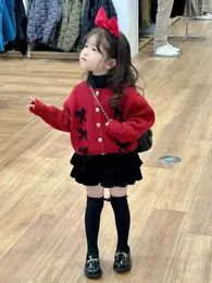 Set di abbigliamento Versione coreana delle ragazze 2024 Autunno / inverno Natale e anno Cardigan lavorato a maglia con fiocco rosso Gonna in velluto per bambina
