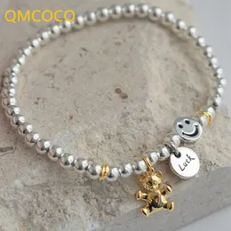 QMCOCO unik kreativ silverfärg rund hängande leende ansikte björn runt pärla armband kvinnor nya koreanska modehandprydnader