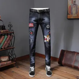 Jeans masculinos Europa Estação Primavera Juventude Personalidade Impresso Crachá Patch Stretch Slim Pés Demin Azul Escuro Homens