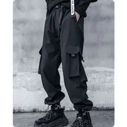 Overalls Männlich, die die vorliegende Hose mit weit geschenkten Hip-Hip-Hop-Tanz-Ziehstrahlstrahl lockern