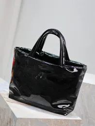 Black patent leather tote bag with a minimalist design and understated style