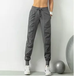 Yoga LL Дышащие спортивные брюки Одежда для спортзала Женские бегуны Быстросохнущие тонкие свободные беговые тренировочные леггинсы для фитнеса Повседневные брюки с девятью карманами lu