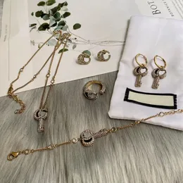 Conjunto de colar de casamento, pulseiras de chave de strass, anéis, brincos de brinco de briwm de desenhos de brinco são para mulheres. Jóias de designer de moda de marca Conjunto com caixa de presente