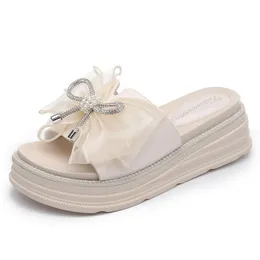 Sandals Sweet Bow Slippers PVC Mulheres 2023 Versão coreana de verão de cunha de sola grossa Aumento do desgaste externo diariamente