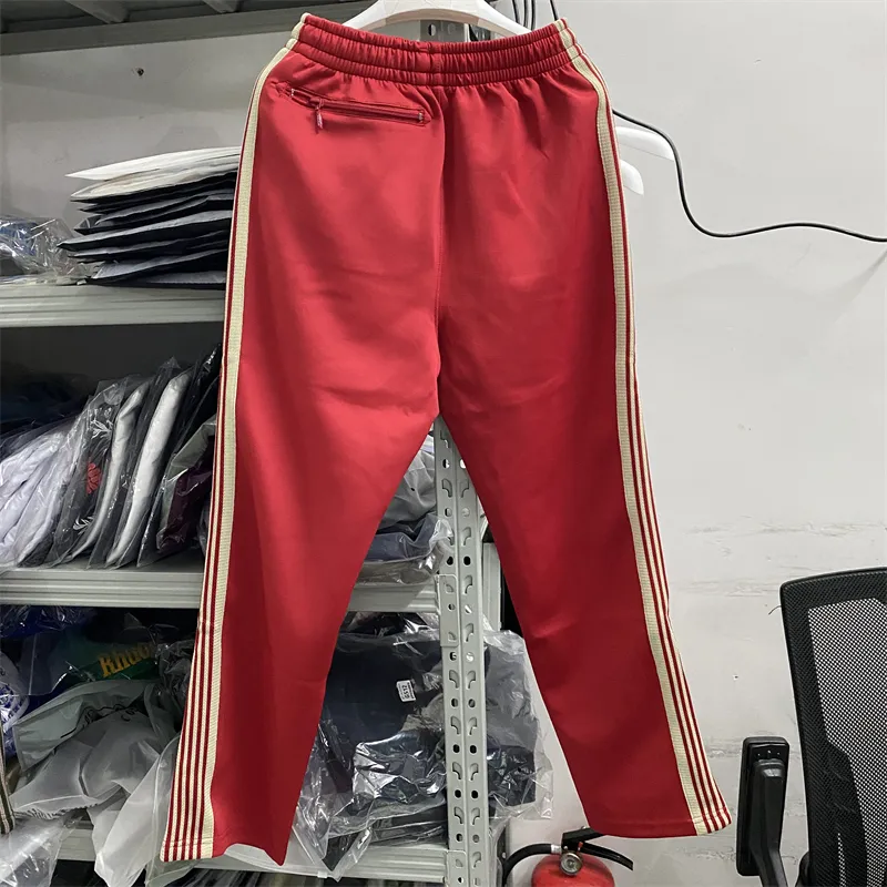 Green track pants with red stripe top